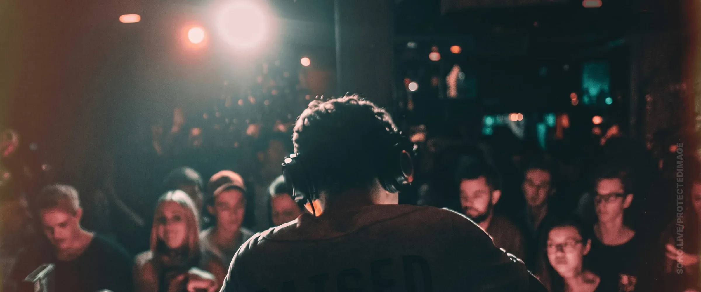 DJ Behind the Decks Facing the Crowd
