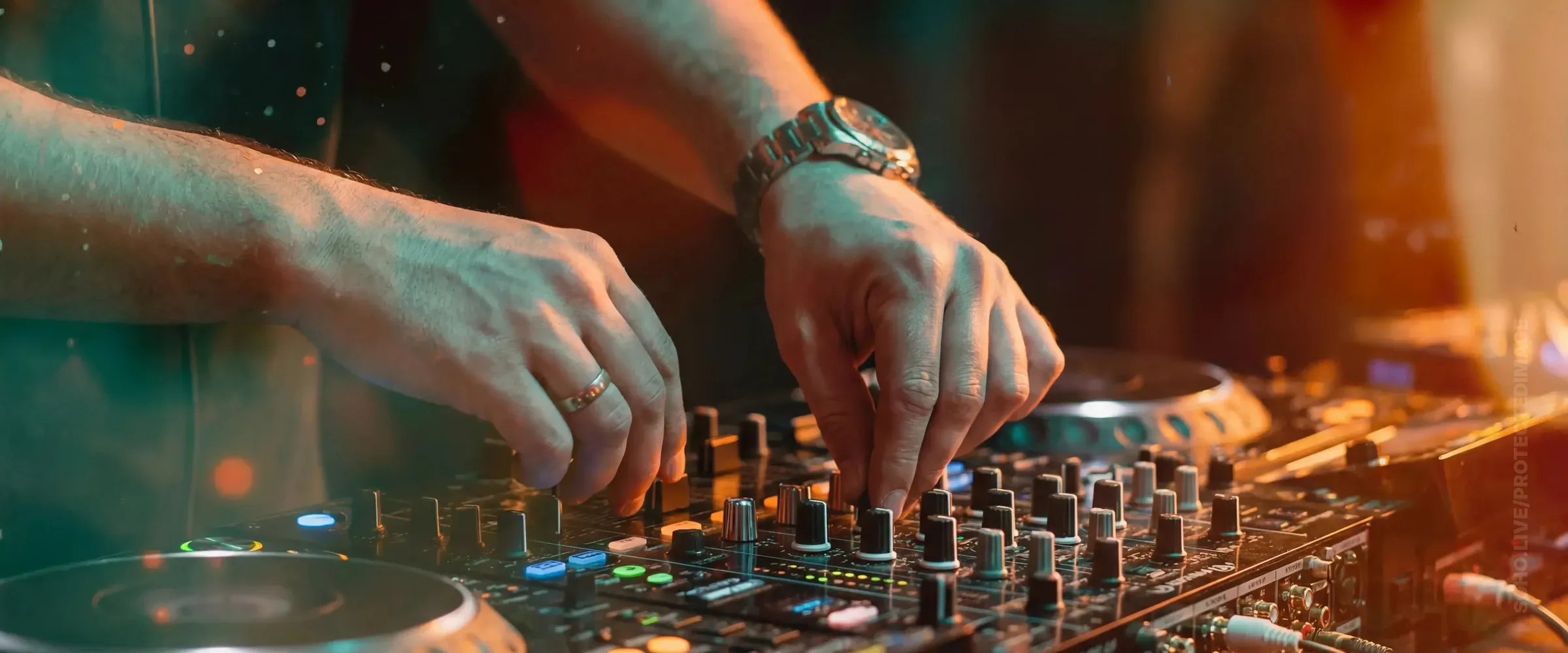 DJ Hands on the Mixer at Night