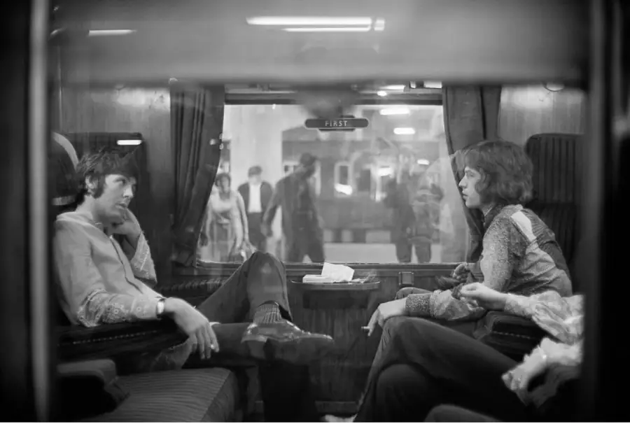Two musicians talking in a train carriage, black and white