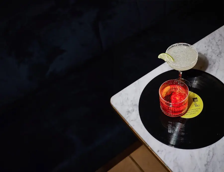 Two cocktails on a record, on a marble table edge