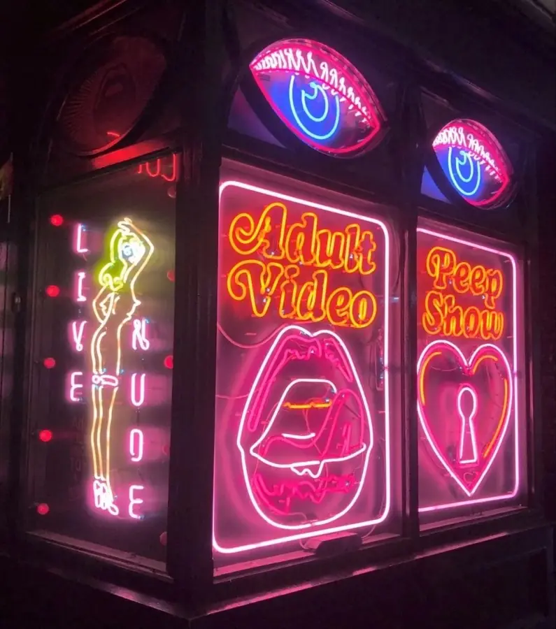 Pink and blue neon signs in a Soho window