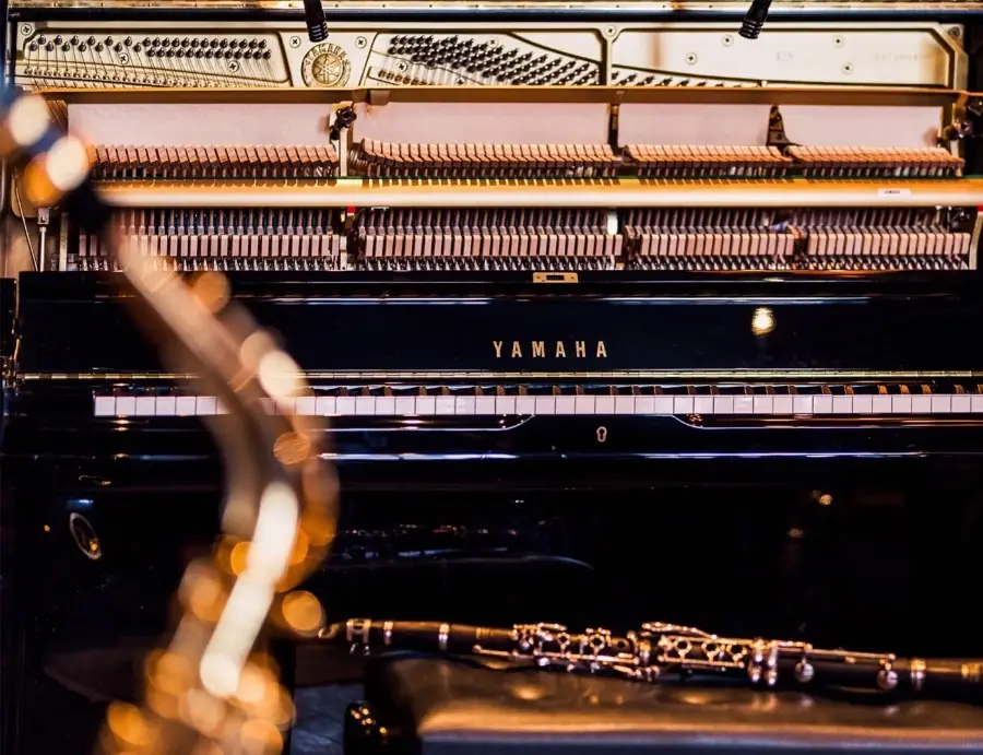 A Yamaha upright with its lid off, clarinet resting below