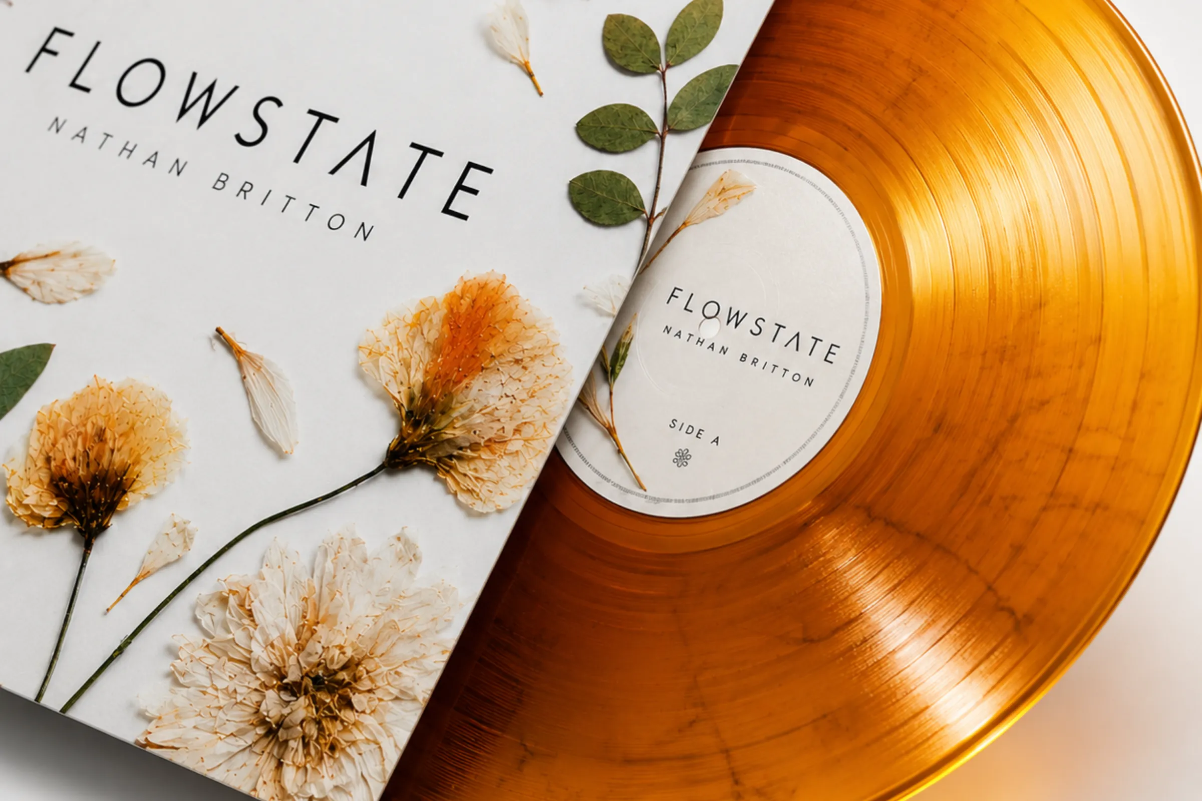 Flowstate album artwork by Nathan Britton, pressed flowers on white, with orange vinyl